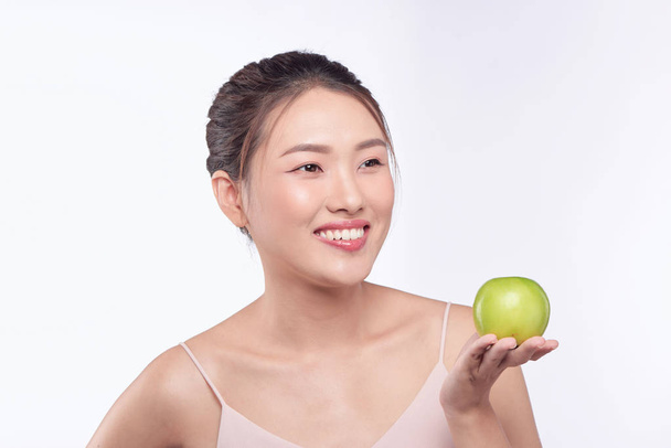 Gyönyörű nő, aki egy zöld alma, elszigetelt fehér háttér.  - Fotó, kép
