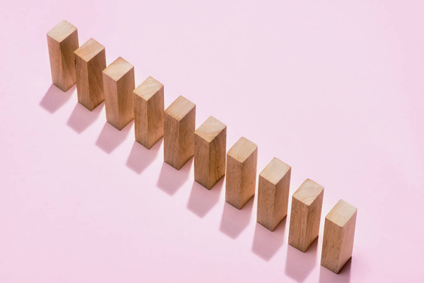 Domino block. Dominoes continuous toppled on pink background. - Foto, immagini