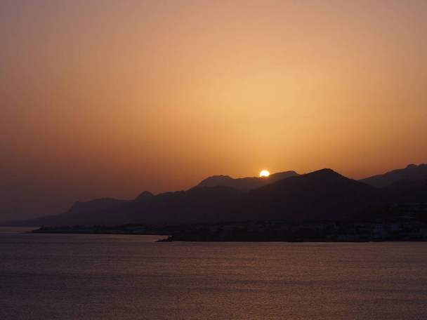 Orangefarbener Strand auf der griechischen Insel bei Sonnenuntergang. - Foto, Bild