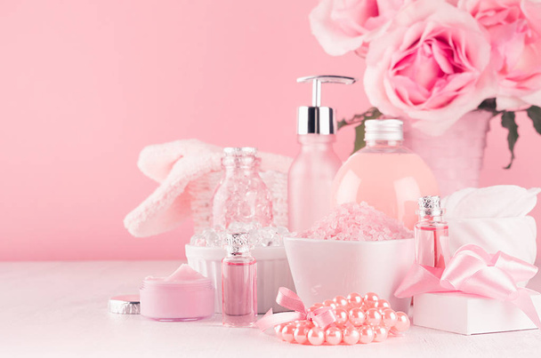 Modern girlish dressing table with pink cosmetics products, accessories and roses bouquet on soft white wood table. - Foto, immagini