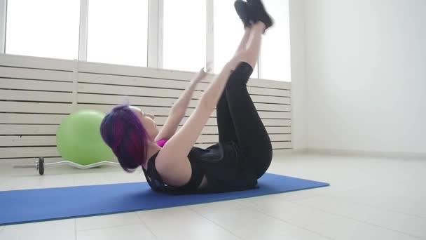Sport and healthy lifestyle concept. Young woman doing physical exercises at home or in the gym - Video, Çekim
