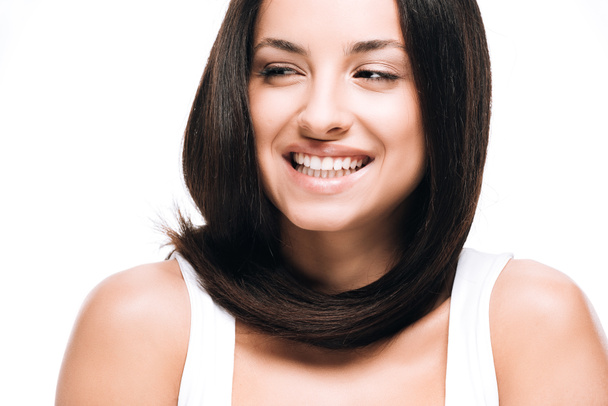 χαμογελαστή μελαχρινή όμορφη γυναίκα με μακρά ίσια υγιή και λαμπερά μαλλιά απομονώνονται σε λευκό - Φωτογραφία, εικόνα