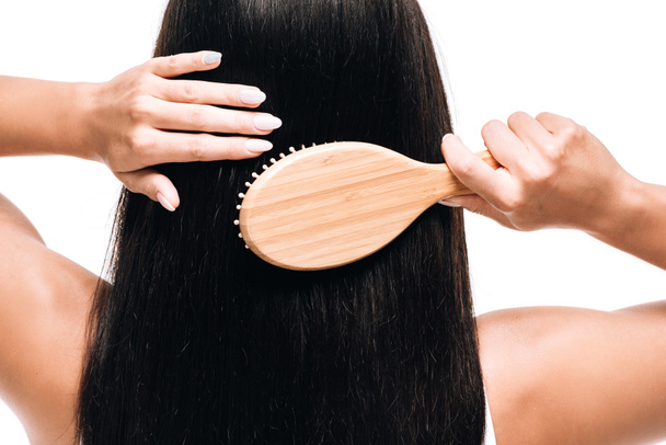 vista posteriore di bruna bella donna spazzolatura lungo dritto capelli sani e lucidi con pettine isolato su bianco
 - Foto, immagini