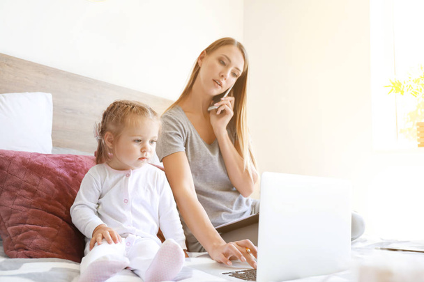 Working mother with her daughter  in bedroom at home - Photo, Image