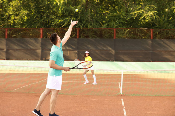 Young couple playing tennis on court - Photo, Image