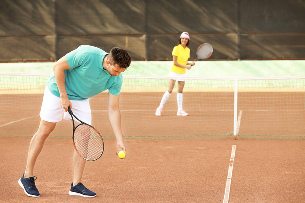 Nuori pari pelaa tennistä kentällä
 - Valokuva, kuva