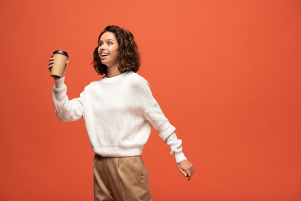  happy woman holding coffee to go isolated on orange - Fotoğraf, Görsel