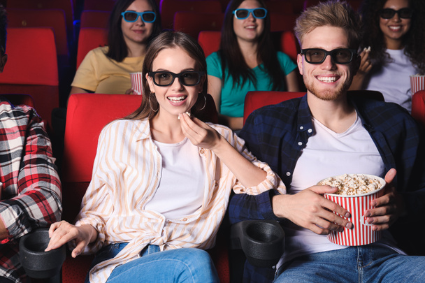 Vrienden met popcorn kijken film in de bioscoop - Foto, afbeelding
