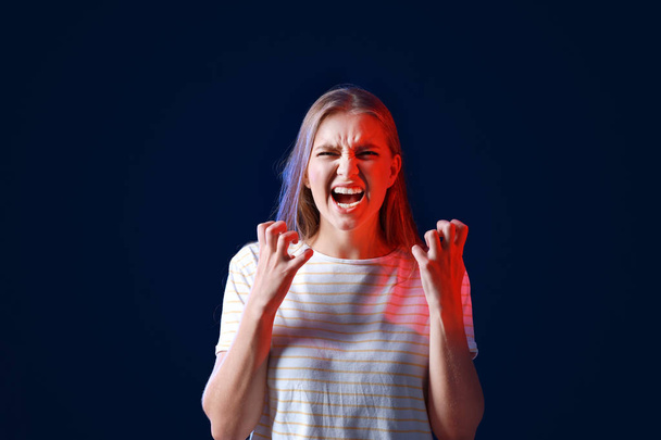 Portret Gniewnej kobiety na ciemnym tle - Zdjęcie, obraz