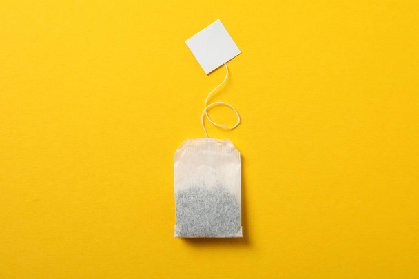 Tea bag with label on yellow background, space for text - Foto, immagini