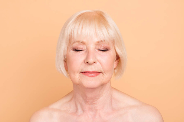 Close-up portrait of her she nice attractive lovely charming groomed peaceful gray-haired lady flawless sensitive skin instant positive effect facial oil balm cream mask isolated over beige background - Φωτογραφία, εικόνα