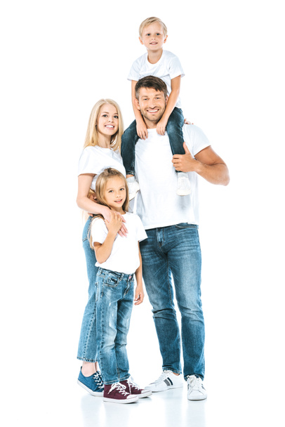 happy father holding son on shoulders near wife and daughter on white - Foto, afbeelding