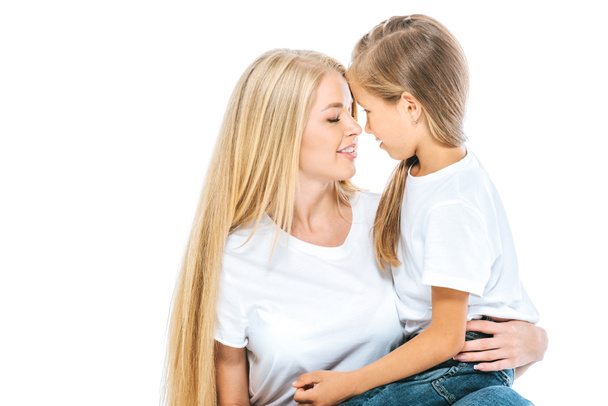 beautiful mother and cute daughter looking at each other isolated on white - Foto, Bild