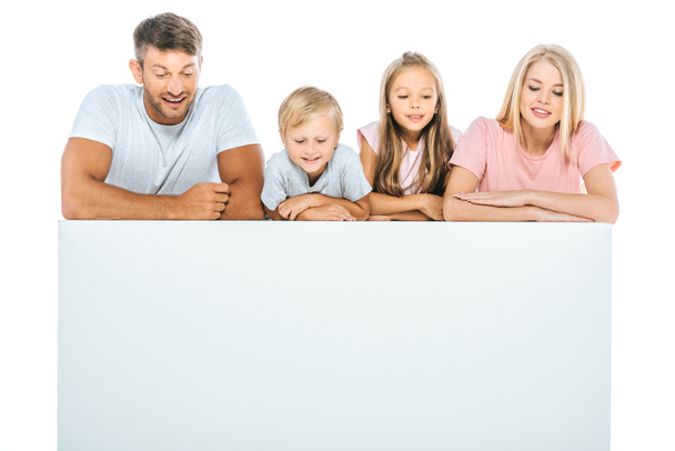 parents and cute kids looking down near blank placard isolated on white - Photo, Image