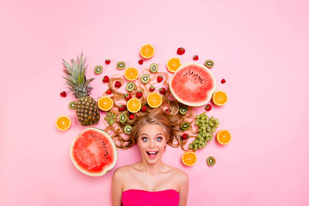 Close up top above high angle view photo beautiful she her lady lying down among different half slices fruits in long volume hair amazing wondered unexpected expression isolated pink background - Valokuva, kuva