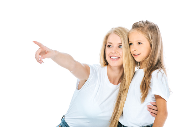 happy woman pointing with finger while hugging daughter isolated on white  - Foto, afbeelding