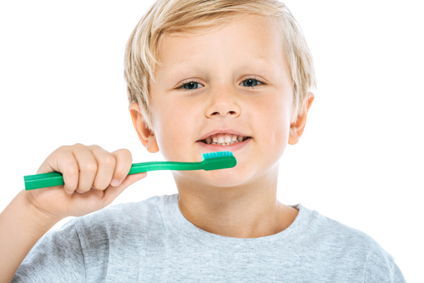 mignon et heureux garçon tenant brosse à dents isolé sur blanc
  - Photo, image