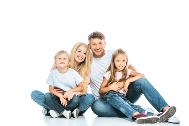 happy parents and kids in blue jeans sitting on white  - Фото, изображение