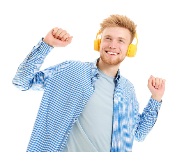 Knappe jongeman, luisteren naar muziek op witte achtergrond - Foto, afbeelding