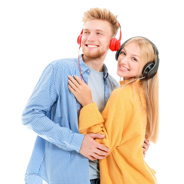 Young couple listening to music on white background - Φωτογραφία, εικόνα