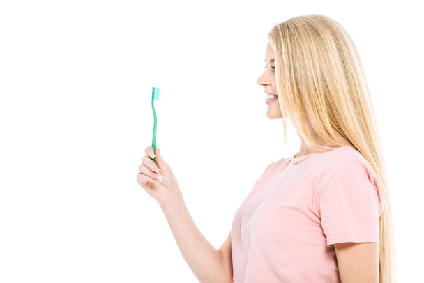 щаслива жінка дивиться на зубну щітку ізольовано на білому
  - Фото, зображення