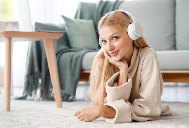 Beautiful young woman listening to music at home - Valokuva, kuva