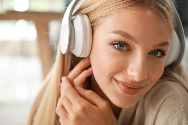 Красивая молодая женщина слушает музыку дома - Фото, изображение