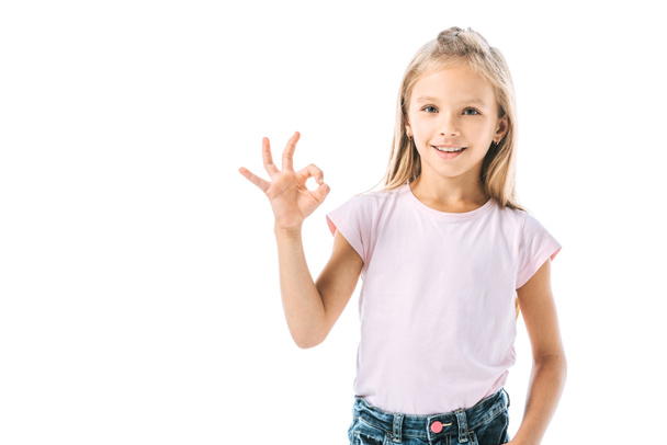 cheerful kid showing ok sign and smiling isolated on white  - Foto, immagini
