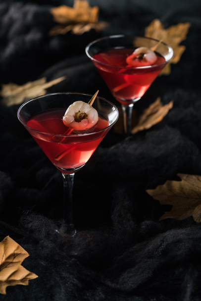 red cocktails with maple dry yellow leaves on black background - Foto, Imagem