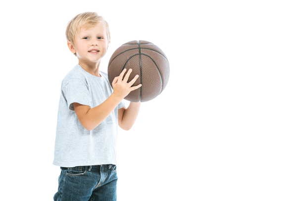 cute boy holding basketball and smiling isolated on white  - Zdjęcie, obraz
