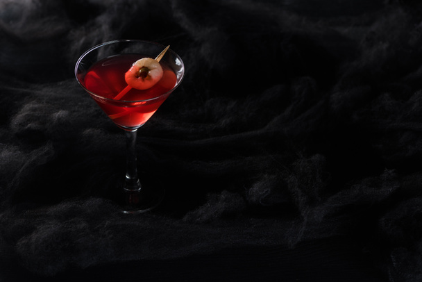 red decorated Halloween cocktail in black clouds - Fotó, kép