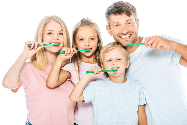 padres y niños felices sosteniendo cepillos de dientes mientras se cepillan los dientes aislados en blanco
 - Foto, Imagen