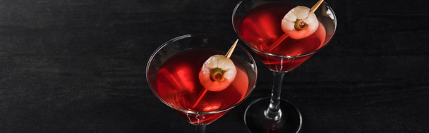 panoramic shot of red decorated Halloween cocktails on black background - Фото, зображення