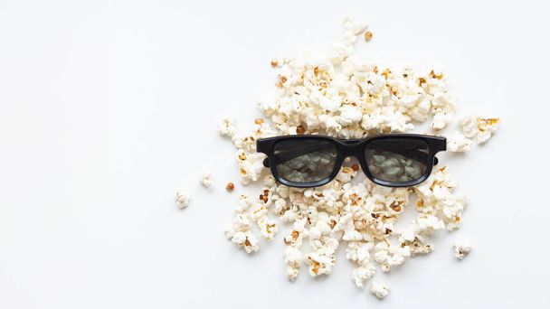 scattered popcorn and 3D glasses on white background. mock up. top view. - Foto, Imagen