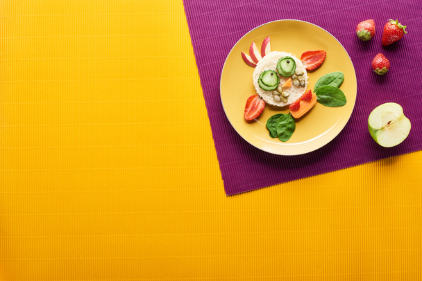 top view of plate with fancy cow made of food on purple and orange background - Foto, imagen