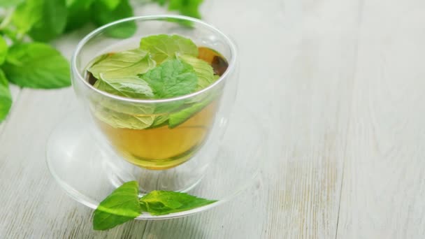 Ένα φλιτζάνι πράσινο τσάι με μέντα και λεμόνι - Πλάνα, βίντεο