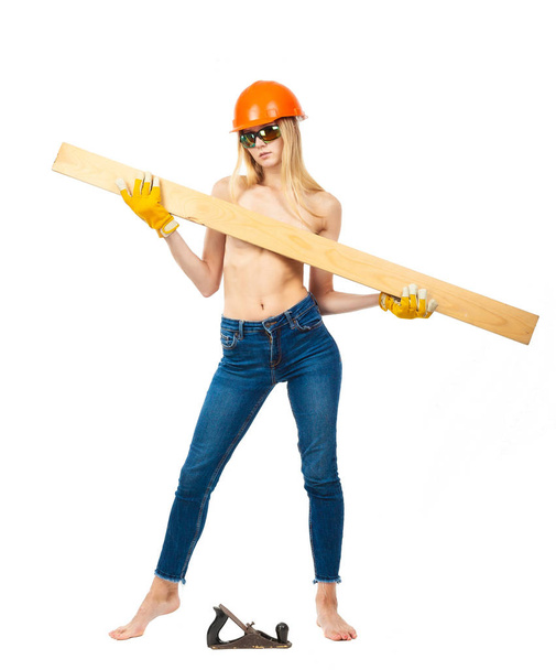 Half-naked blonde in jeans in a construction helmet with a plane and a board on a white background. - Foto, immagini