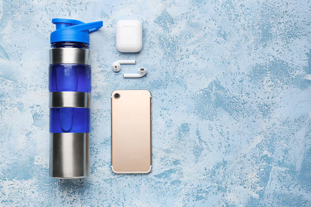 Esportes garrafa de água, telefone celular e fones de ouvido no fundo de cor
 - Foto, Imagem