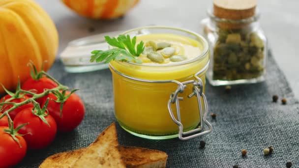 cremige Kürbissuppe im Glas mit Brot und Tomaten - Filmmaterial, Video