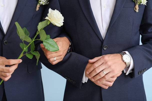 Gelukkig Gay paar op hun trouwdag tegen kleur achtergrond, close-up - Foto, afbeelding