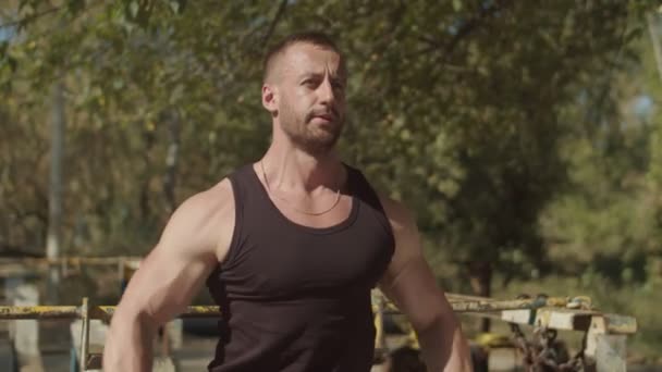 Muscular man doing dumbbell shoulder fly outdoors - Πλάνα, βίντεο