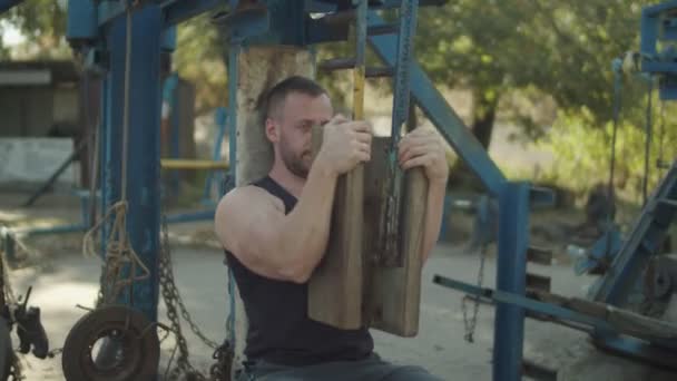 Strong man flexing muscles on chest press machine - Кадри, відео