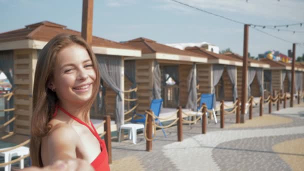 Porträt von glücklich lächelnden Mädchen, die während des Sommerurlaubs in einem teuren Resort in einen Bungalow gehen, folgen Sie mir - Filmmaterial, Video