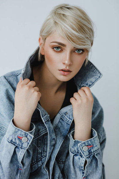 Portrait of fashion blonde woman with short hair wearing denim jacket  - Foto, afbeelding