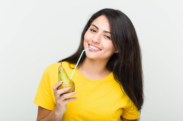 わらで梨ジュースを飲む若いヒスパニック女性 - 写真・画像