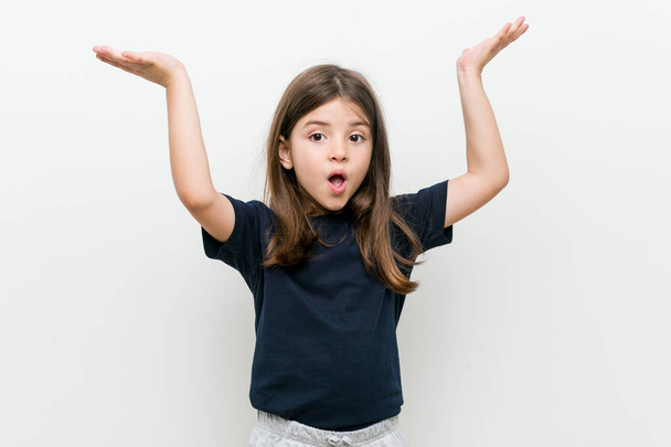 Χαριτωμένο μικρό καυκάσιο κορίτσι γιορτάζει μια νίκη ή την επιτυχία - Φωτογραφία, εικόνα