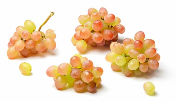 Composition of grapes raisins of different sizes and points of shooting. White isolated background. Bright saturated colors of red and yellow. - Фото, зображення