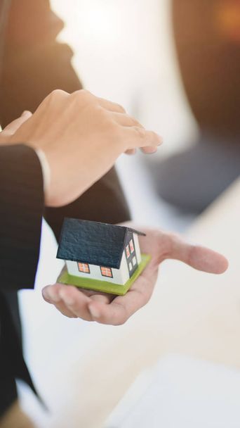 Επιχειρηματίας που κρατά ένα μοντέλο σπιτιού στο ένα χέρι - Φωτογραφία, εικόνα