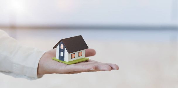 Immobilienversicherungskonzept: Versicherungsvertreter hält ein Hausmodell in der Hand - Foto, Bild