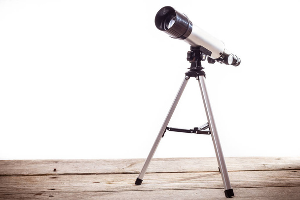 Teleskop auf weißem Hintergrund auf Holzbrett gelegt - Foto, Bild